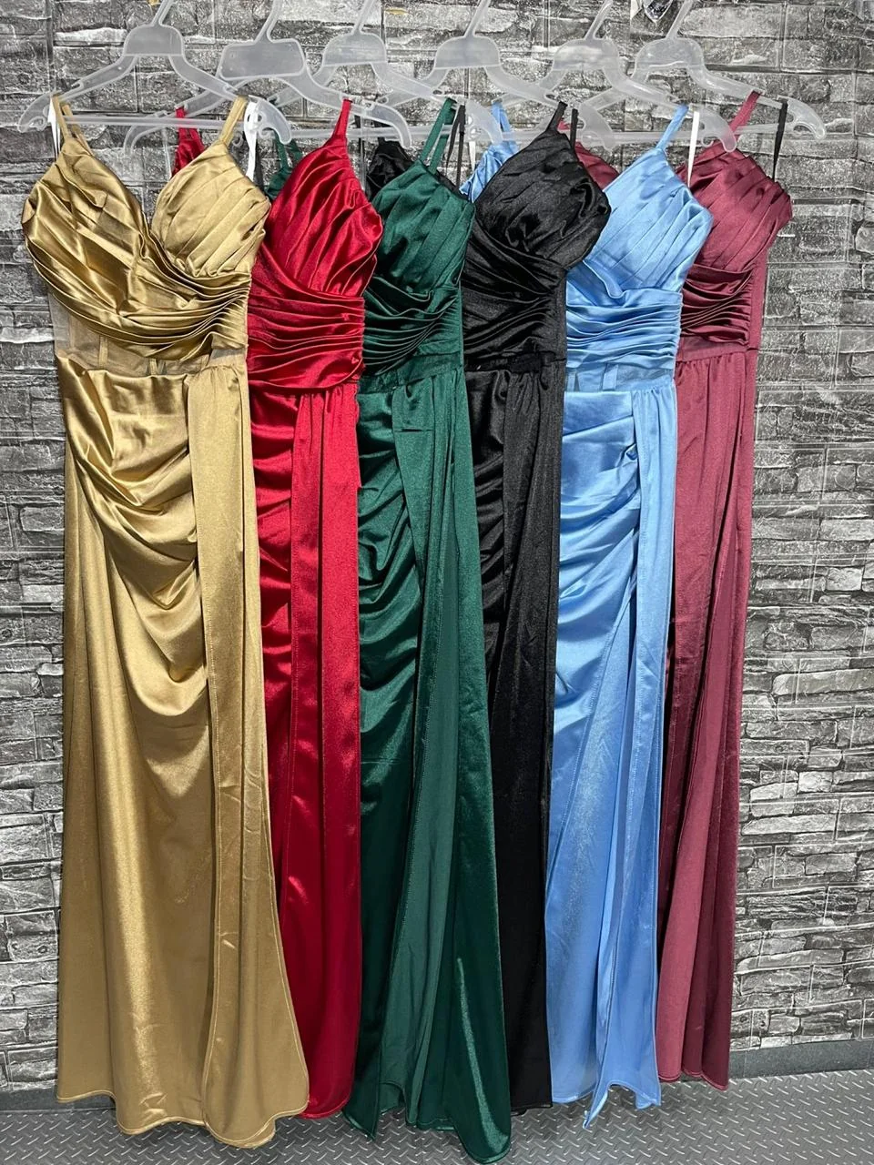 Colores Disponibles Vestido Satinado Patrizze | Proveedor Mixcalco Exhibición de vestidos de gala satinados en colores dorado, rojo, verde esmeralda, negro, azul cielo y vino, disponibles para venta por lote en Patrizze.